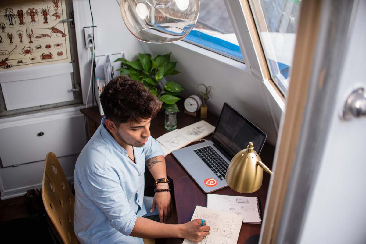 san diego man sits while writing in front of MacBook united states
